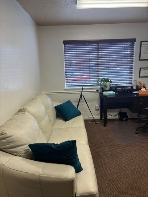 Counseling office with a cream couch and teal cushions
