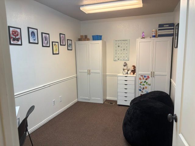 Children’s room with toys, storage cabinets, and a beanbag seat
